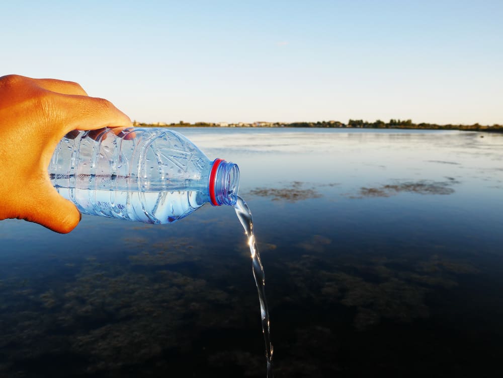 bouteille d'eau potable versée dans une rivière